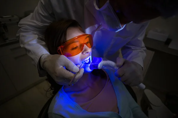 Tandläkaren undersöker en kvinnlig patient med dental verktyg — Stockfoto