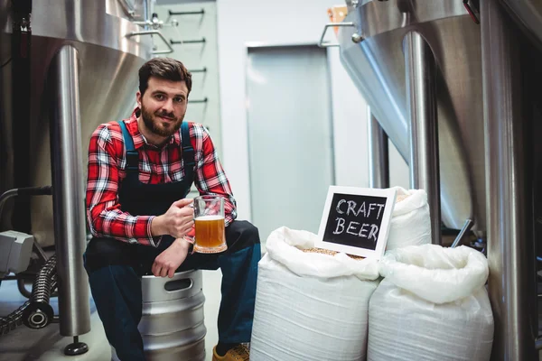 Fabricante sosteniendo vaso de cerveza en la cervecería — Foto de Stock