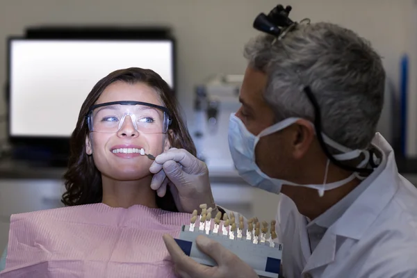 Dentista examinando paciente do sexo feminino com tons de dentes — Fotografia de Stock