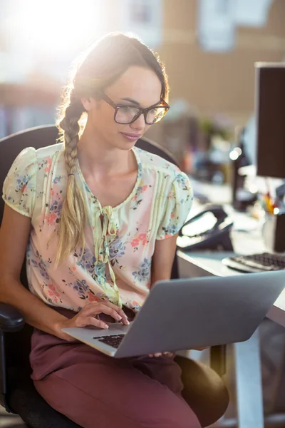 Woman sitting on chair and using laptop — Stock Photo, Image