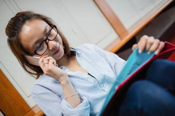 Mujer joven hablando por teléfono móvil en vestuario — Foto de Stock