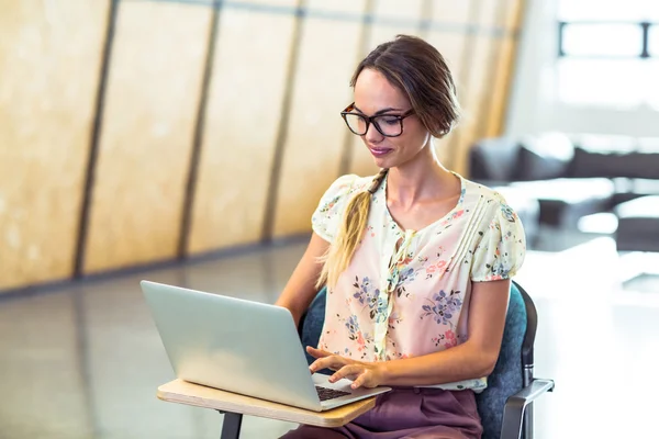 Kvinna sitter på stol och använder laptop — Stockfoto
