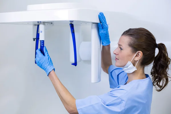 Dental assistant adjusting x-ray equipment — Stock Photo, Image