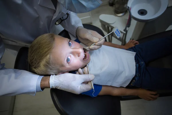Dentysta, badając młodego pacjenta z narzędzia — Zdjęcie stockowe