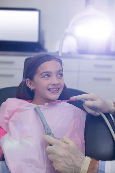 Dentista examinando um paciente jovem com ferramentas — Fotografia de Stock