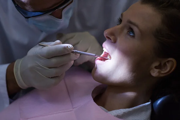 Dentista examinando um paciente com ferramentas — Fotografia de Stock