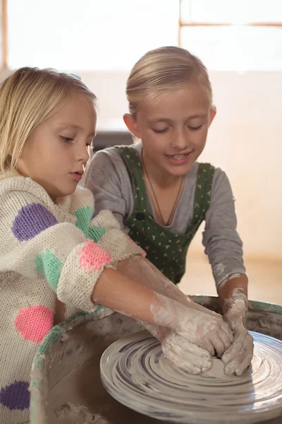 Smiling girls making pot — Stock Photo, Image