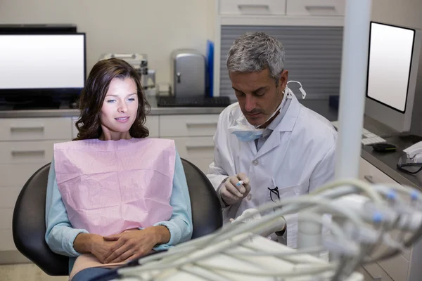 Dentist showing mouth model to female patient — Stock Photo, Image