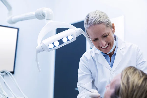 Dentista examinando um paciente com ferramentas — Fotografia de Stock