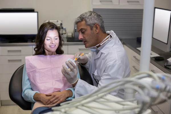 Стоматолог показывает модель рта пациентке — стоковое фото