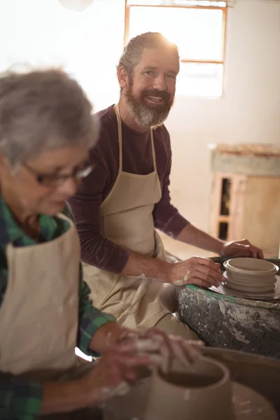 Чоловічий гончар посміхається під час виготовлення горщика — стокове фото