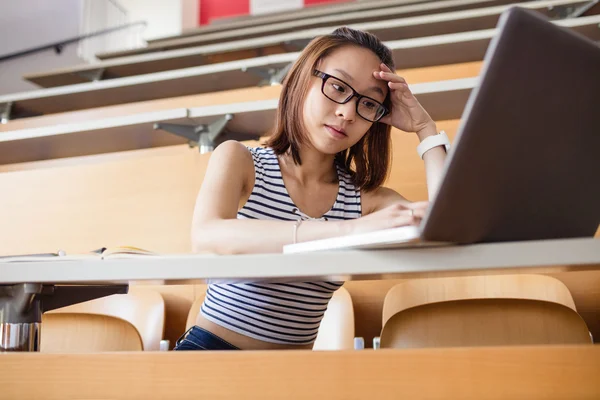 紧张的女人在教室里使用笔记本电脑 — 图库照片