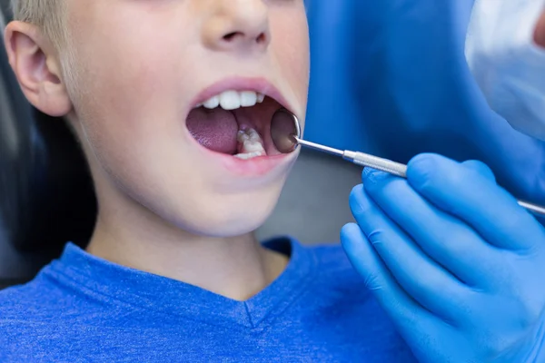 Dentista examinando um paciente jovem com ferramentas — Fotografia de Stock