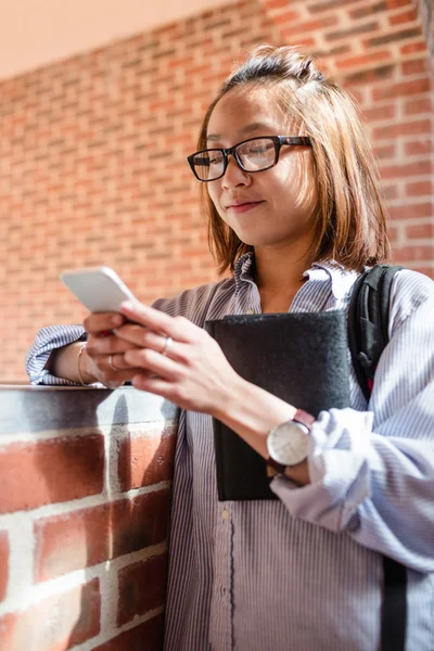 若い女性が廊下で携帯電話を使用して — ストック写真