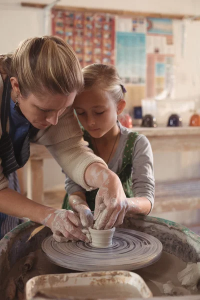 Female potter assisting girl — Stock Photo, Image