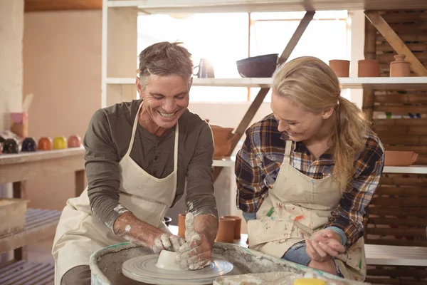 Male potter assisting female potter — Stock Photo, Image