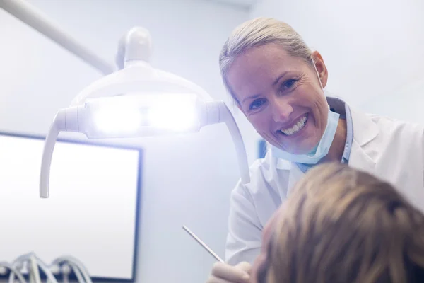 Dentista examinando a un paciente con herramientas —  Fotos de Stock