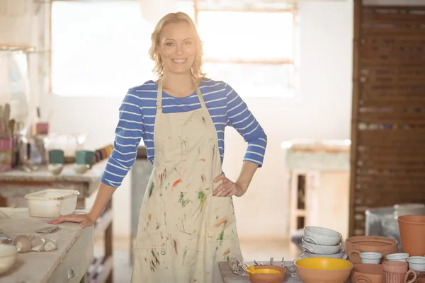 Female potter standing in pottery shop — Stock Photo, Image