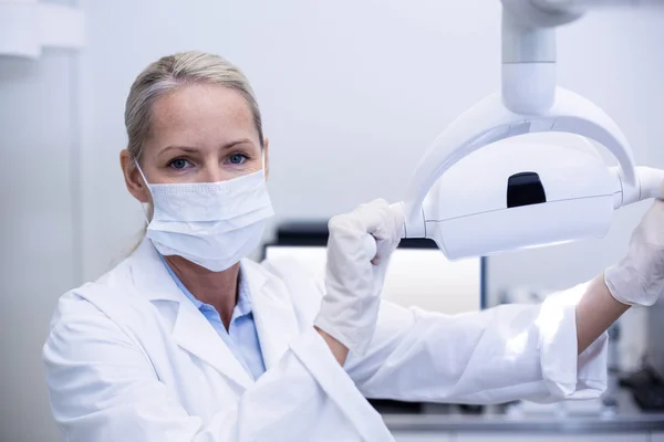 Dentiste femelle tenant des lumières dentaires — Photo