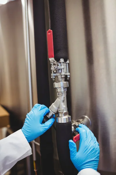 Brewery manufacturer adjusting pipe on storage tank — Stock Photo, Image