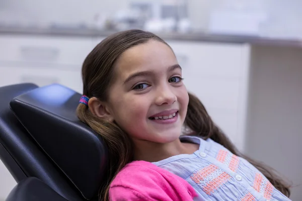 Glimlachend jonge patiënt zittend op de stoel van de tandartsen — Stockfoto