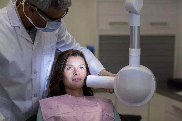 Ο οδοντίατρος εξετάζει μια γυναίκα ασθενής με οδοντιατρικό εργαλείο — Φωτογραφία Αρχείου