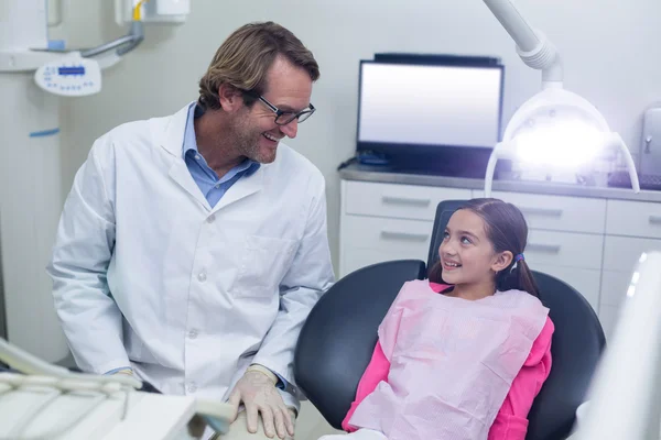 Lachende tandarts in gesprek met jonge patiënt — Stockfoto