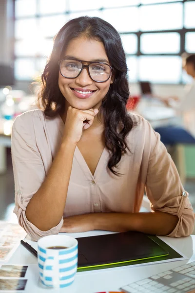 Businesswoman sitting at table and smiling — Stock Photo, Image