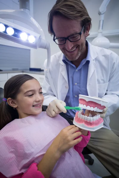 Dentista mostrando giovane paziente come lavarsi i denti — Foto Stock