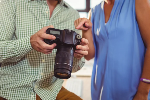 Diseñador gráfico mostrando foto a colega en cámara digital — Foto de Stock