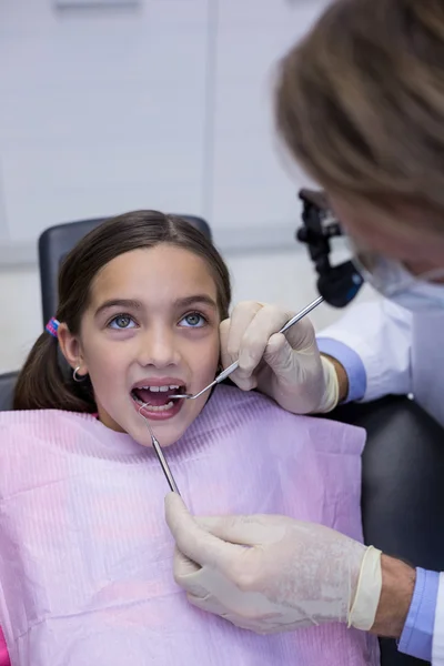 Dentista examinando um paciente jovem com ferramentas — Fotografia de Stock