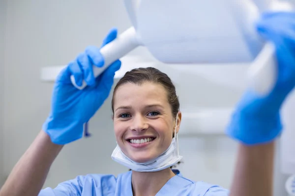 Retrato de assistente dentário ajustando a luz — Fotografia de Stock