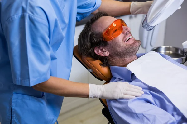 Assistente dentário examinando jovem paciente boca — Fotografia de Stock