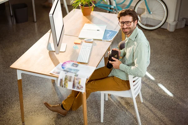 Graphic designer looking at pictures in digital camera — Stock Photo, Image