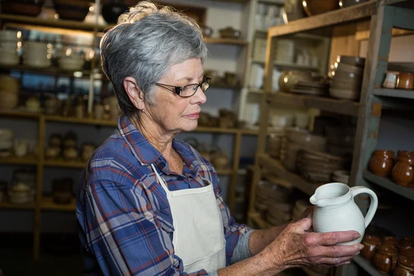 Kvinnliga potter kontroll jug — Stockfoto