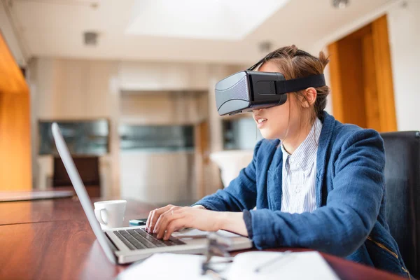 Девушка в очках виртуальной реальности с помощью ноутбука — стоковое фото