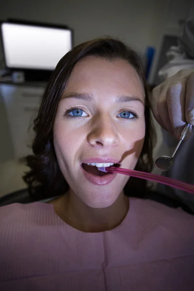 Dentist examining a female patient with tools — Stock Photo, Image