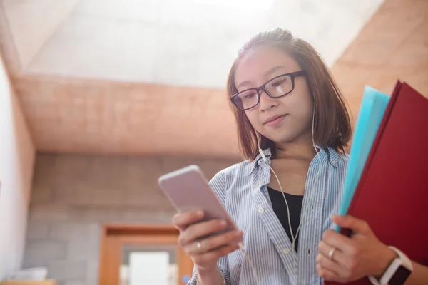 Mujer joven usando el teléfono móvil en el pasillo —  Fotos de Stock