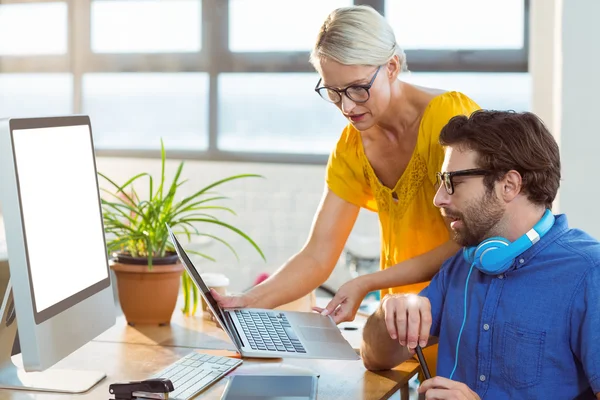 Grafiska formgivare diskuterar över laptop — Stockfoto