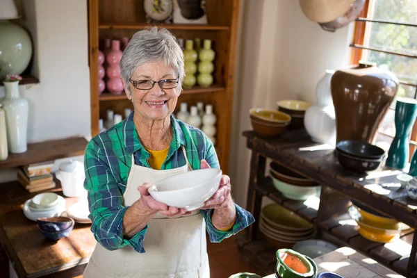 Female potter holding bowl — Stock Photo, Image