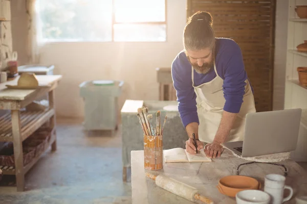 Potter writing on a book — Stock Photo, Image