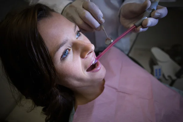 Ο οδοντίατρος εξετάζει μια γυναίκα ασθενής με εργαλεία — Φωτογραφία Αρχείου