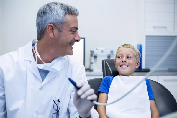 Dentista sorridente che parla con un giovane paziente — Foto Stock