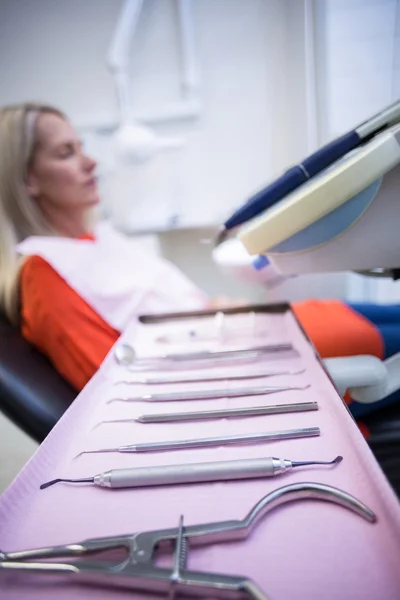 Mujer relajante en silla de dentista con herramientas dentales en primer plano —  Fotos de Stock