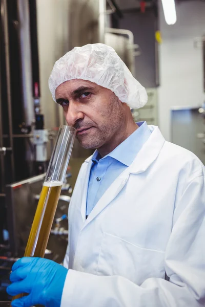 Portrait of manufacturer examining beer in brewery — Stock Photo, Image