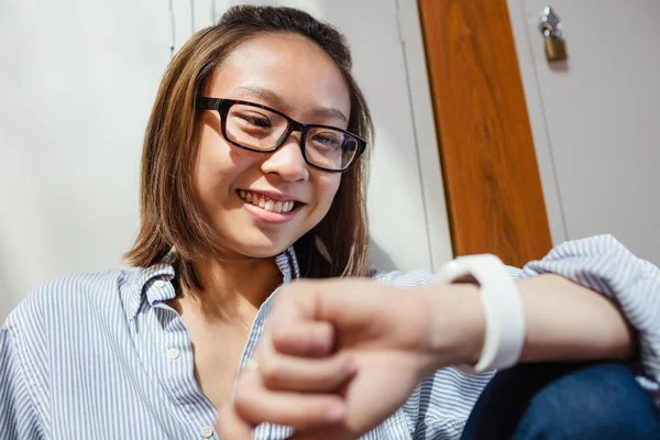 幸福的年轻女人，检查时间对 smartwatch 在更衣室内 — 图库照片