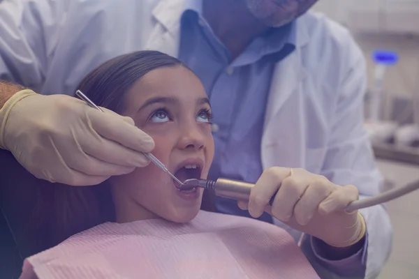 Dentista examinando um paciente jovem com ferramentas — Fotografia de Stock