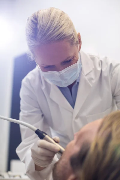 Dentiste examinant un patient avec des outils — Photo