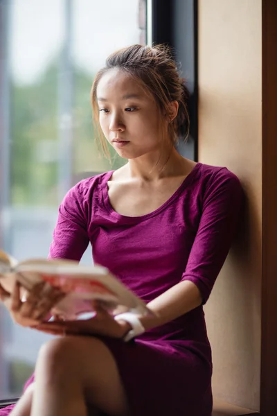 Junge Frau liest Buch im College — Stockfoto