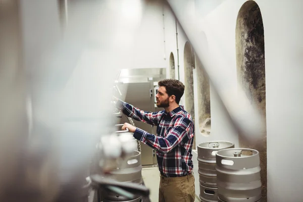 Fabricante inspeccionando maquinarias en cervecería — Foto de Stock